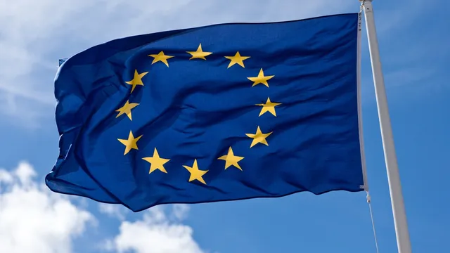 De vlag van de Europese Unie wappert tegen een blauwe lucht, symbool voor de Europese digitale soevereiniteit die in dit onderzoek centraal staat.