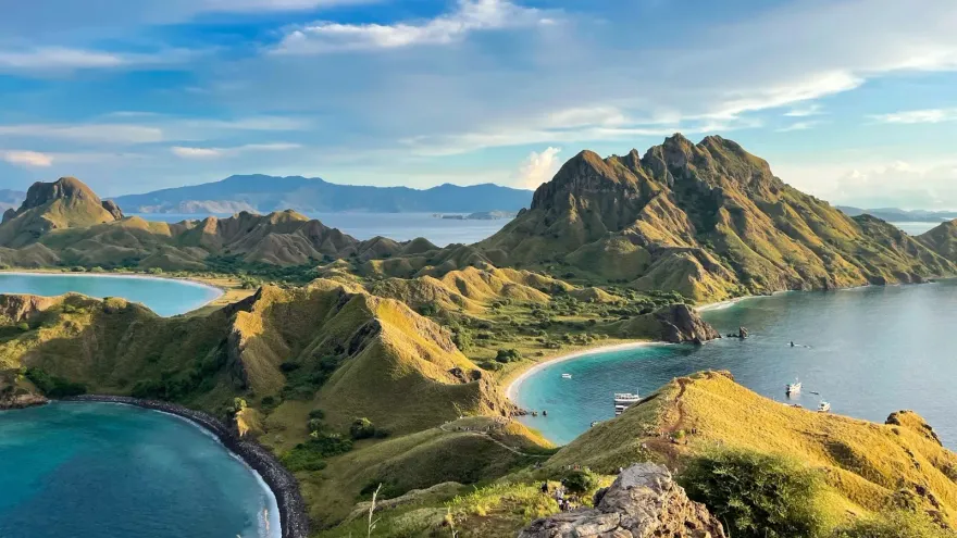Luchtfoto van groene vulkanische eilanden en turquoise baaien, een landschap dat verwijst naar de natuurlijke hulpbronnen die GreenPT helpt te beschermen.